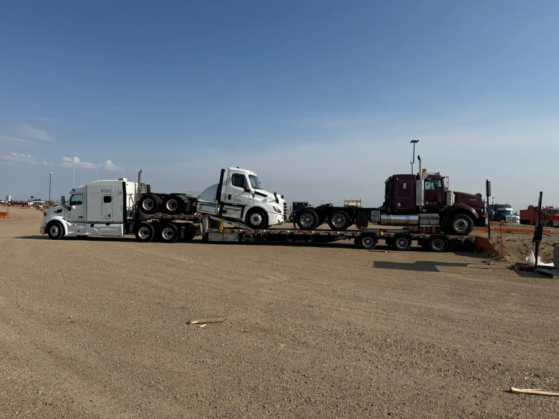 Flatbed trailer and equipment units awaiting haul-out from commercial yard